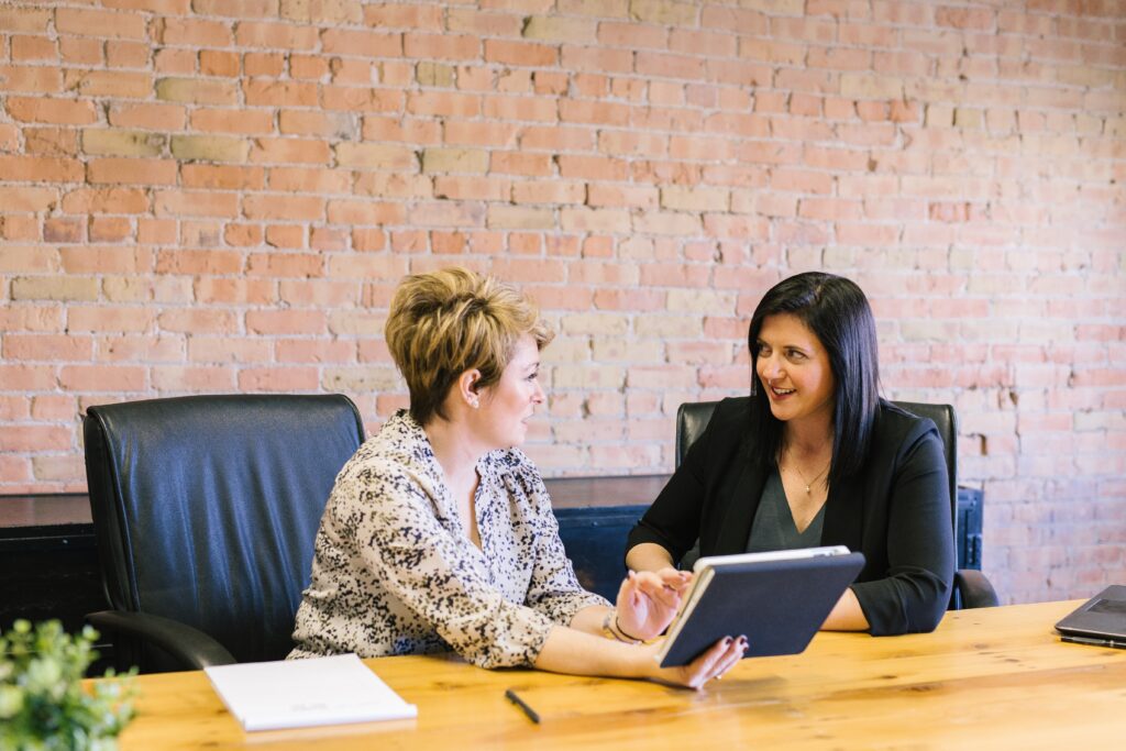 two women at a desk talking