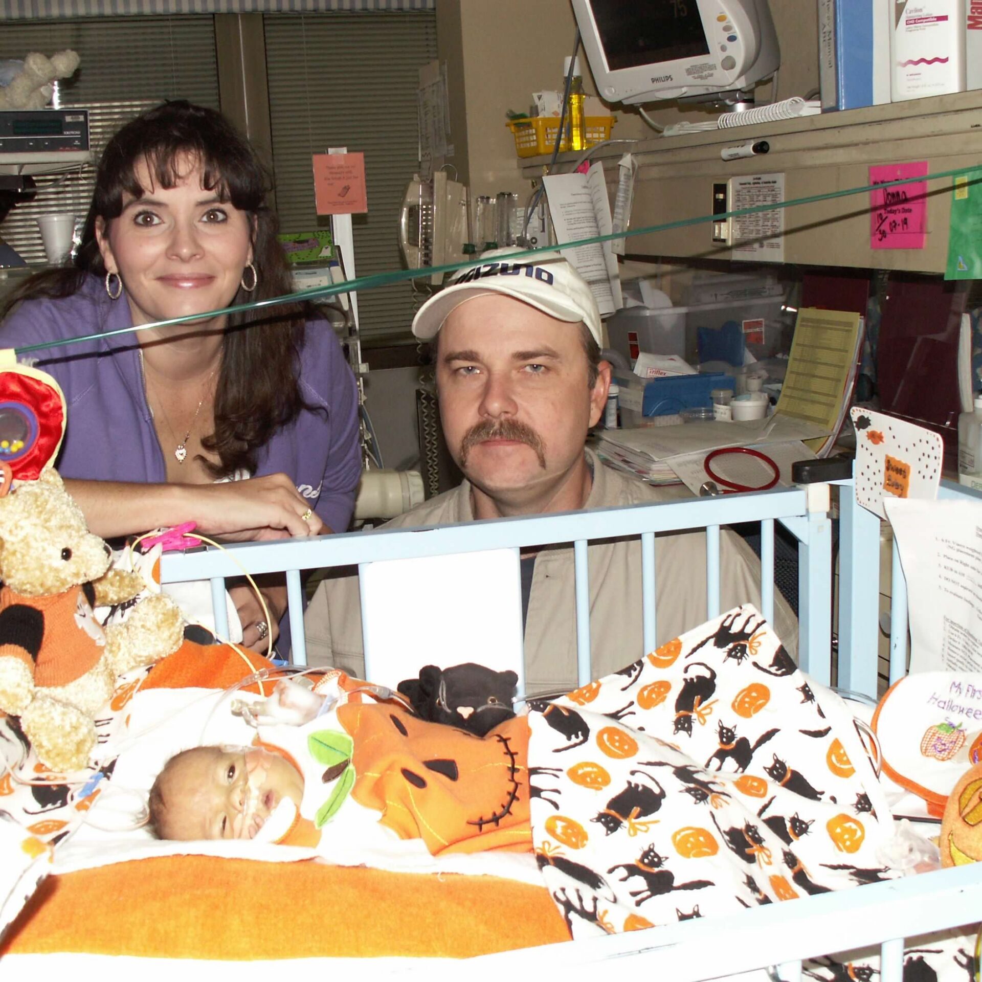 mother and father in the neonatal intensive care unit with their baby